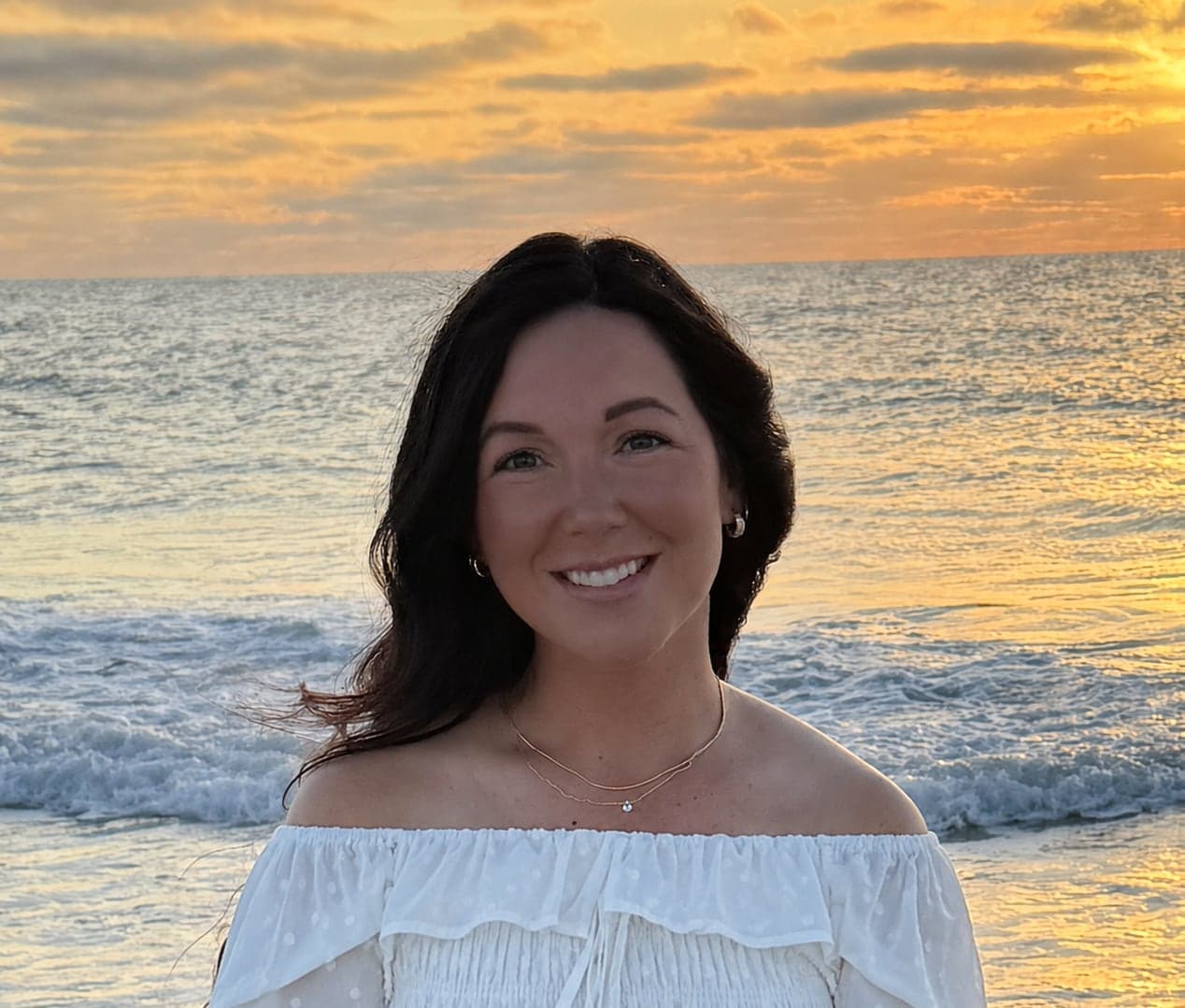 Chantelle, founder of Blue Shore Interiors, on the beach at sunset